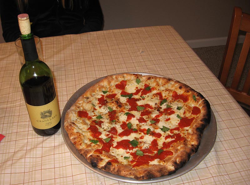 Pizza is cooked and it is on the table.