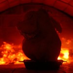 Roasting chicken in a heat from wood fire in pizza oven.