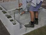 Raising block walls with dry stack cement blocks filled with concrete.