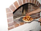 This is how you can twist pizza and placing it into the fired dome again.