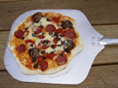 Picture of wood fired pizza that has been just taken out from the oven.