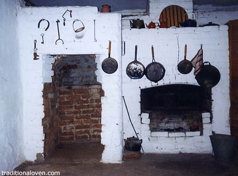 Photograph of fireplace and wood firing oven in an old cottage kitchen.