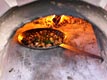 Preparing hot-pan meal inside clay oven.