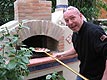 Making pizza in forno wood fired brick oven.