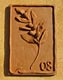 Ceramic tile representing an olive branch.