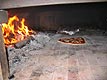 Wood fired pizza is being done inside Italian forno garden backyard family oven.