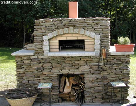 Backyard garden pizza oven built of stones on outside.