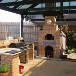Outdoors kitchen with oven for pizza.