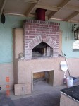 Under roof covered wood burning oven