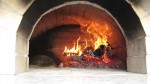 Brick oven with going on wood heating fire