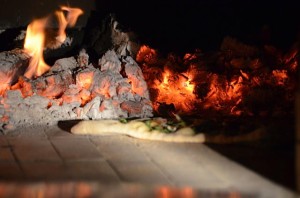 Pizza being cooked on hot bricks