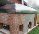 fireplace with oven and metal hood cover