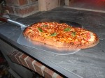 Ready pizza outside fire oven