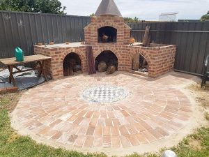A round ground mosaic from bricks and tiles with fireplace plus oven.