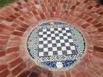 Circular ground mosaic of tiles and bricks.